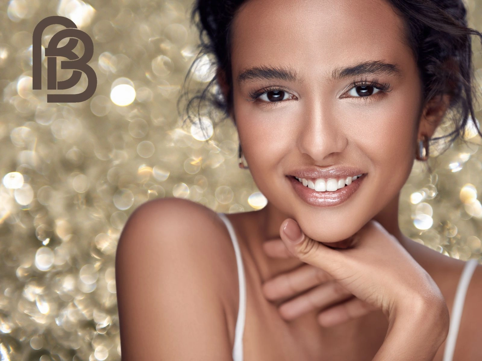 Model with a natural mineral makeup look and a glossy lip, smiling, with the BareFaced Beauty monogram